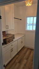 Laundry room featuring dark wood-type flooring and an inviting chandelier