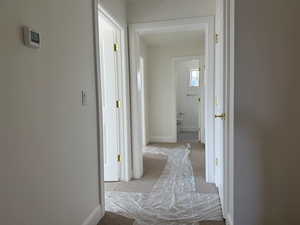 Corridor with baseboards and carpet flooring