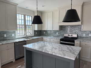 Kitchen featuring extractor fan, wood finished floors, a sink, a kitchen island, and appliances with stainless steel finishes