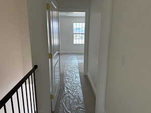 Hallway with carpet floors and baseboards