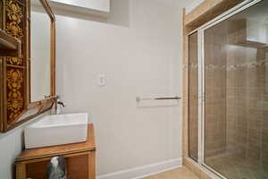 Bathroom with tile patterned flooring, vanity, and a shower with shower door