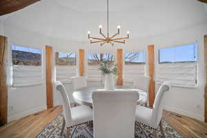 Dining space featuring lofted ceiling, an inviting chandelier, and light hardwood / wood-style floors