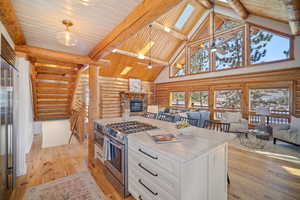 Kitchen featuring white cabinetry, hanging light fixtures, a skylight, and appliances with stainless steel finishes