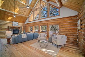 Living room featuring a fireplace, ceiling fan, wooden ceiling, beam ceiling, and light hardwood / wood-style flooring