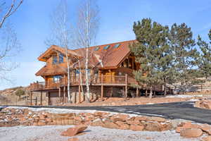 Snow covered house featuring a garage and a deck