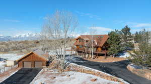 Log cabin with a garage and a deck with mountain view