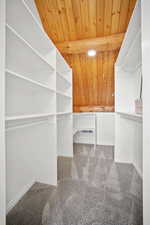 Walk in closet featuring beamed ceiling and carpet flooring