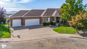 View of front of home with a garage, a mountain view, and a front yard