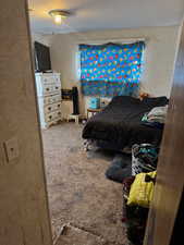 Carpeted bedroom featuring a textured ceiling