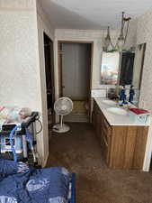 Bathroom featuring a textured ceiling, vanity, and toilet