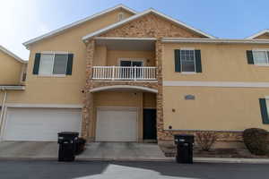 View of property with a garage and a balcony