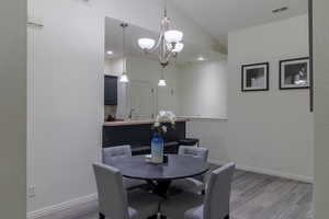 Dining room with lofted ceiling, wood-type flooring, and sink