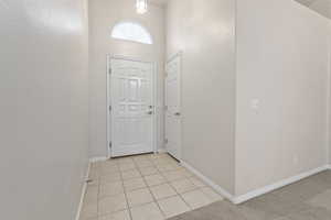 Tiled entrance foyer featuring a high ceiling