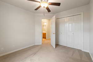 Unfurnished bedroom with light carpet, ceiling fan, and a closet