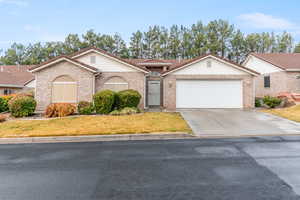 View of front of property featuring a front lawn and a garage