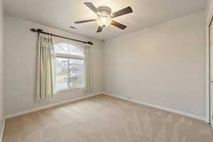 Carpeted empty room with ceiling fan and a textured ceiling