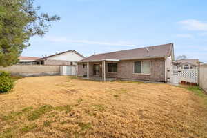 Back of house with a patio area and a lawn