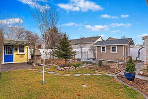 Back of house featuring a shed and a lawn