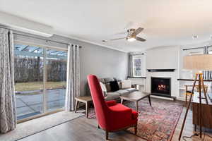 Living room featuring ceiling fan, crown molding, and wood-type flooring