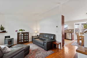 Living room featuring light wood-type flooring and lofted ceiling