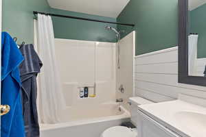 Full bathroom featuring toilet, shower / tub combo with curtain, and vanity