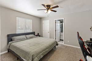 Bedroom with ceiling fan, ensuite bath, and light carpet