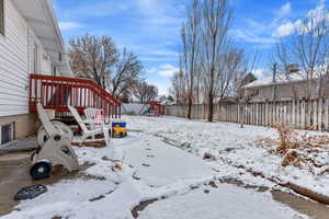 Snowy yard featuring a playground