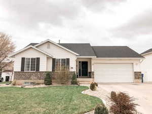 Ranch-style house featuring a front yard and a garage