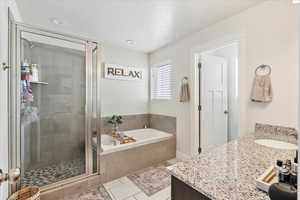 Bathroom with separate shower and tub, vanity, and tile patterned flooring