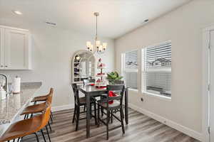 Dining room with an inviting chandelier and light hardwood / wood-style flooring