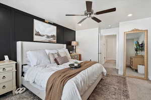 Bedroom featuring a textured ceiling, dark carpet, and ceiling fan