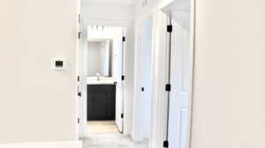 Hallway featuring sink and light colored carpet