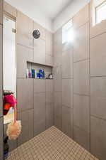 Bathroom featuring a wealth of natural light and tiled shower