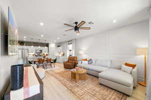 Living room with ceiling fan and light wood-type flooring