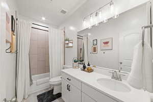 Full bathroom featuring tile patterned flooring, vanity, toilet, and shower / tub combo