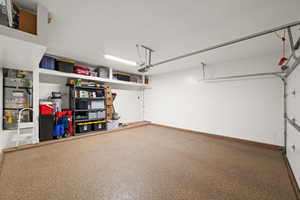 Garage with strapped water heater and a garage door opener