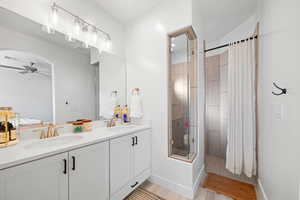 Bathroom with hardwood / wood-style flooring, ceiling fan, curtained shower, and vanity