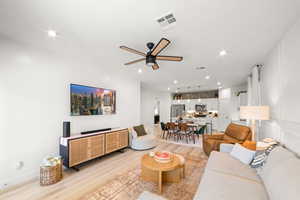 Living room with light hardwood / wood-style flooring and ceiling fan