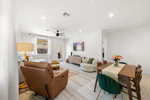 Living room with ceiling fan and light hardwood / wood-style flooring