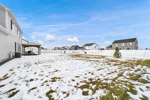 Yard covered in snow featuring cooling unit and a gazebo