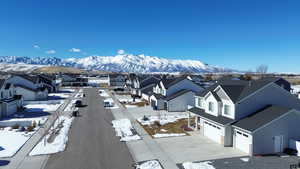 Snowy aerial view featuring a residential view and a mountain view