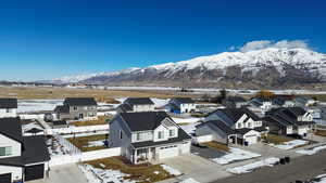 Snowy aerial view featuring a residential view and a mountain view