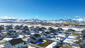 Snowy aerial view featuring a residential view and a mountain view