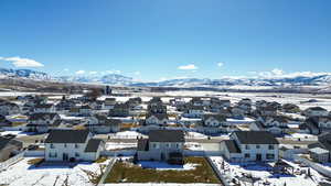 Snowy aerial view featuring a residential view and a mountain view