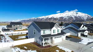 View of front of home with driveway, a residential view, an attached garage, fence private yard, and a mountain view