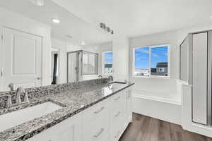 Bathroom featuring hardwood / wood-style flooring, vanity, and shower with separate bathtub