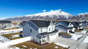 View of front facade featuring driveway, a fenced backyard, a residential view, and a mountain view