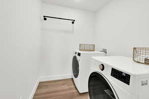 Laundry room with washer and dryer and hardwood / wood-style flooring