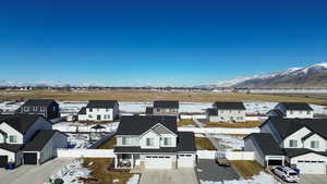 Snowy aerial view featuring a residential view and a mountain view