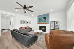 Living room with ceiling fan and light hardwood / wood-style flooring